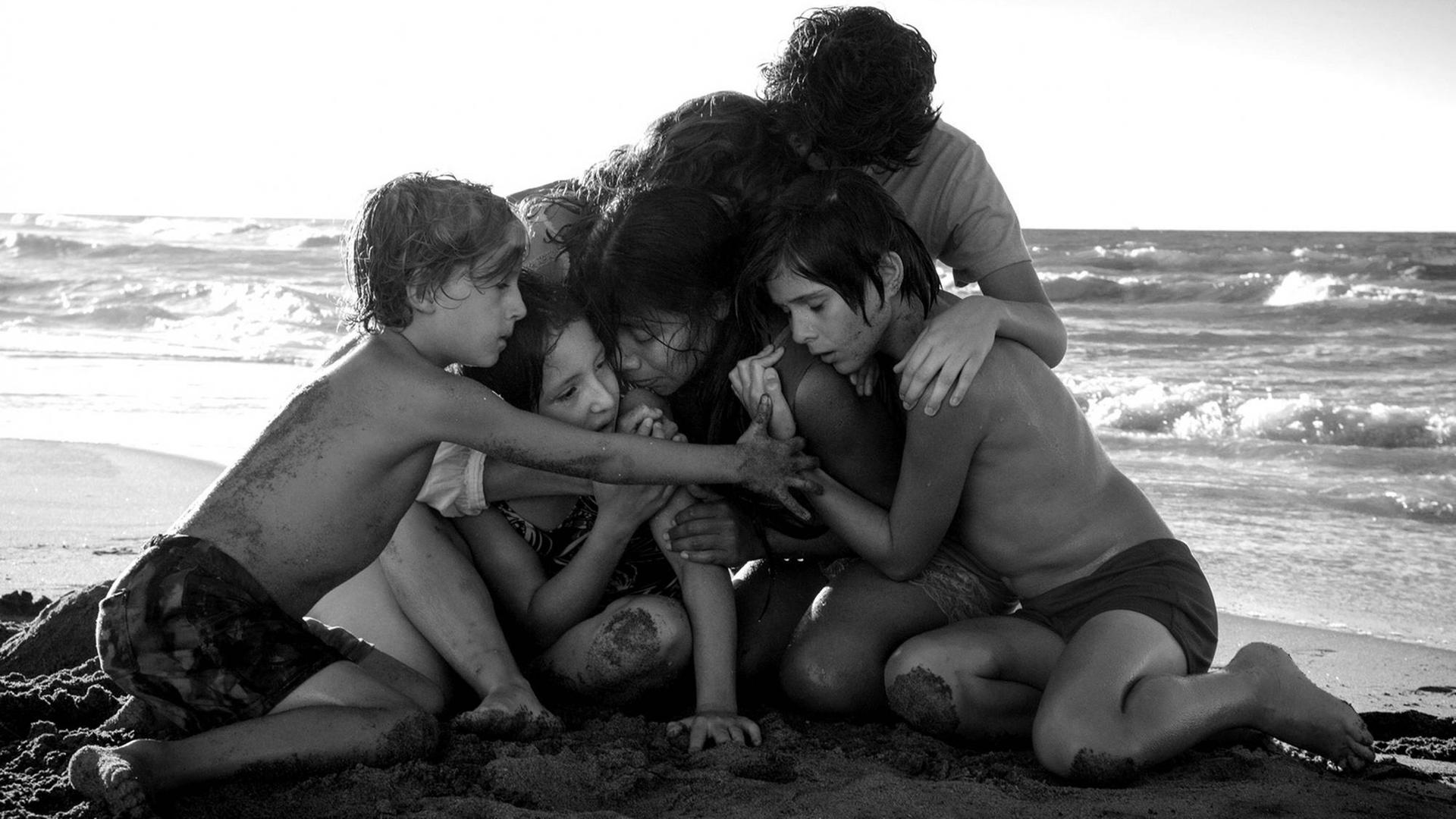 Filmszene aus Cuaróns "Roma": Die jugendlichen Hauptdarsteller kauern am Strand und umarmen sich.