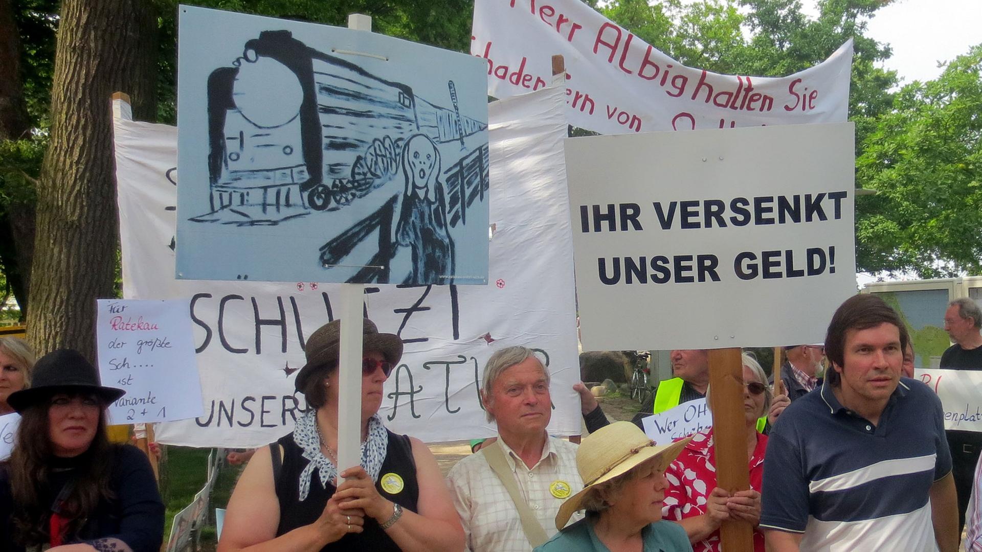 Demonstranten warten am 12.06.2013 am Bahnhof von Timmendorfer Strand (Schleswig-Holstein) auf Ministerpräsident Albig und Bahnchef Grube. Spitzen von Bahn und Politik hatten sich zur Erörterung der unterschiedlichen Möglichkeiten zum Anschluss des geplanten Fehmarnbelt-Tunnels an das Bahnnetz in Ostholstein getroffen.