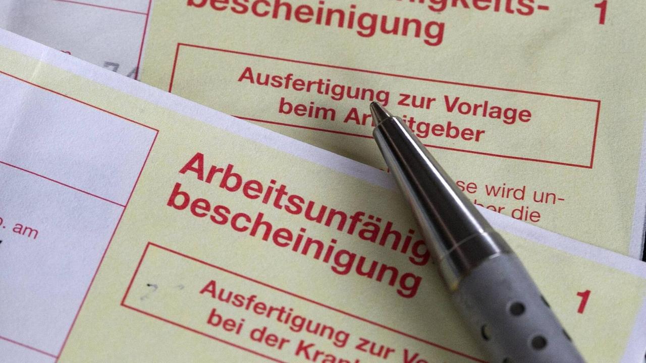 Zu sehen sind zwei Arbeitsunfähigkeitsbescheinigungen - eine zur Vorlage bei der Krankenasse und eine andere zur Vorlage beim Arbeitgeber.