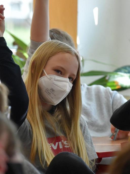 Kinder in Schulklasse mit Maske während der Corona-Pandemie