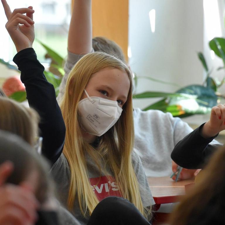 Kinder in Schulklasse mit Maske während der Corona-Pandemie