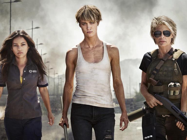 Das Bild zeigt drei kämpferisch schauende Frauen mit Waffen aus dem Film "Terminator: Dark Fate"
