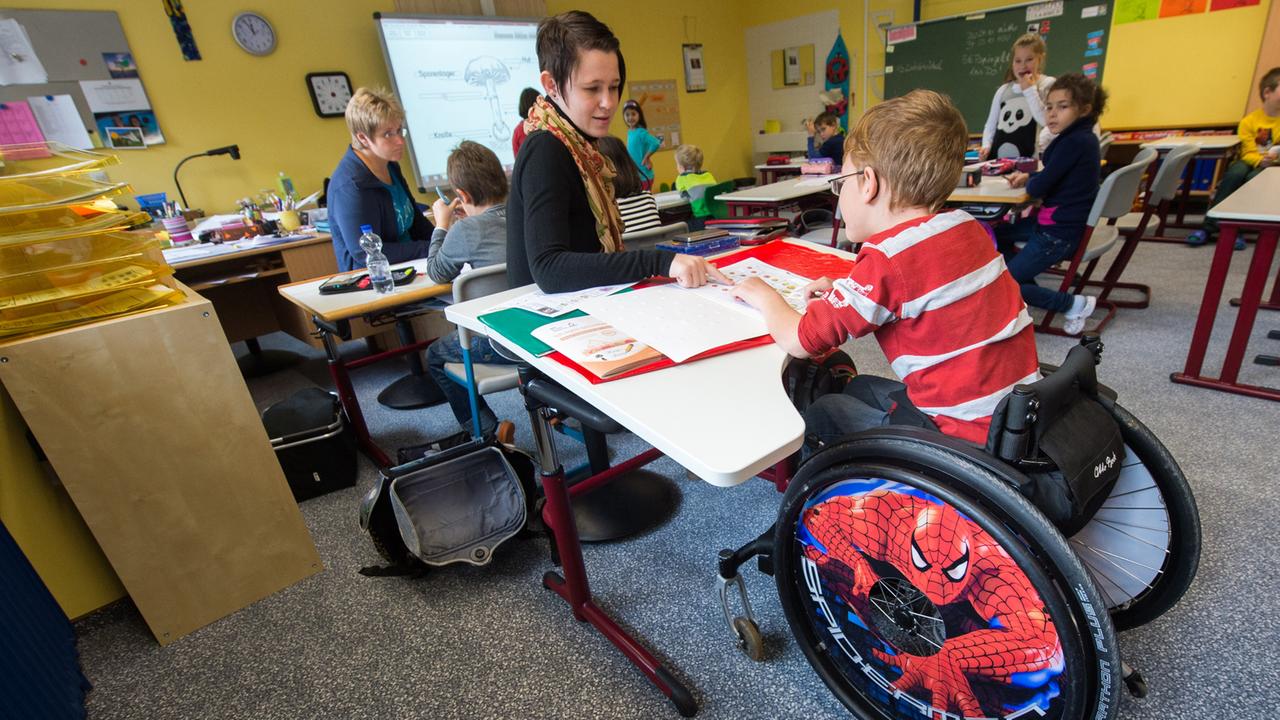 In einer Grundschul-Klasse sitzt ein Junge im Rollstuhl