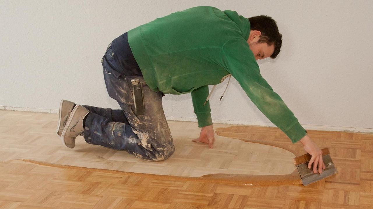 Ein Parkettleger verteilt am 23.01.2012 in einer Wohnung in Hannover nach dem Abschleifen des Parketts Holzkittpaste auf dem rauen Boden. Ein Parkettleger verteilt am 23.01.2012 in einer Wohnung in Hannover nach dem Abschleifen des Parketts Holzkittpaste auf dem rauen Boden.