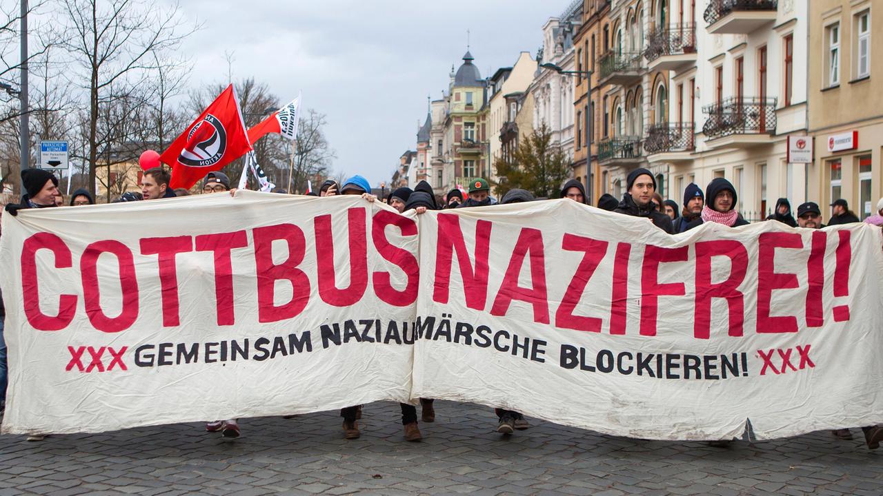 Protest gegen NPD-Aufmarsch in Cottbus. Demonstrationsteilnehmer tragen einen Banner mit der Aufschrift "Cottbus Nazifrei" vor sich her.

