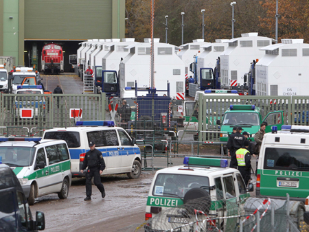Abdeckhauben für Castorbehälter zum Transport auf der Straße stehen am Freitag (05.11.10) an der Verladestation in Dannenberg bereit, während im Vordergrund mehrere Fahrzeuge der Polizei zu sehen sind.
