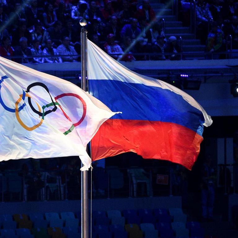 Die olympische und die russische Flagge nebeneinander bei den Winterspielen in Sotschi 2014.