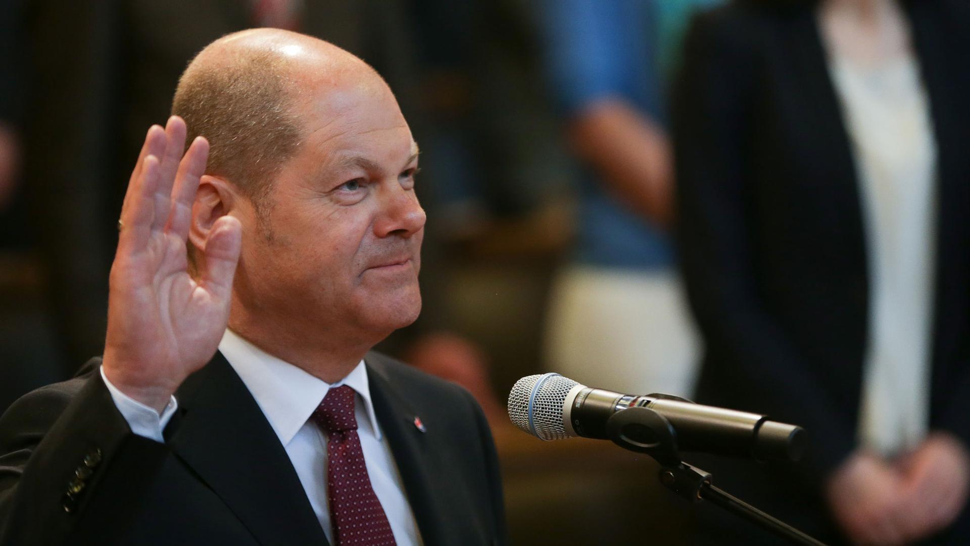 Hamburgs Bürger-Meister Olaf Scholz (SPD) hebt in der Hamburgischen Bürgerschaft die Hand zum Eid.