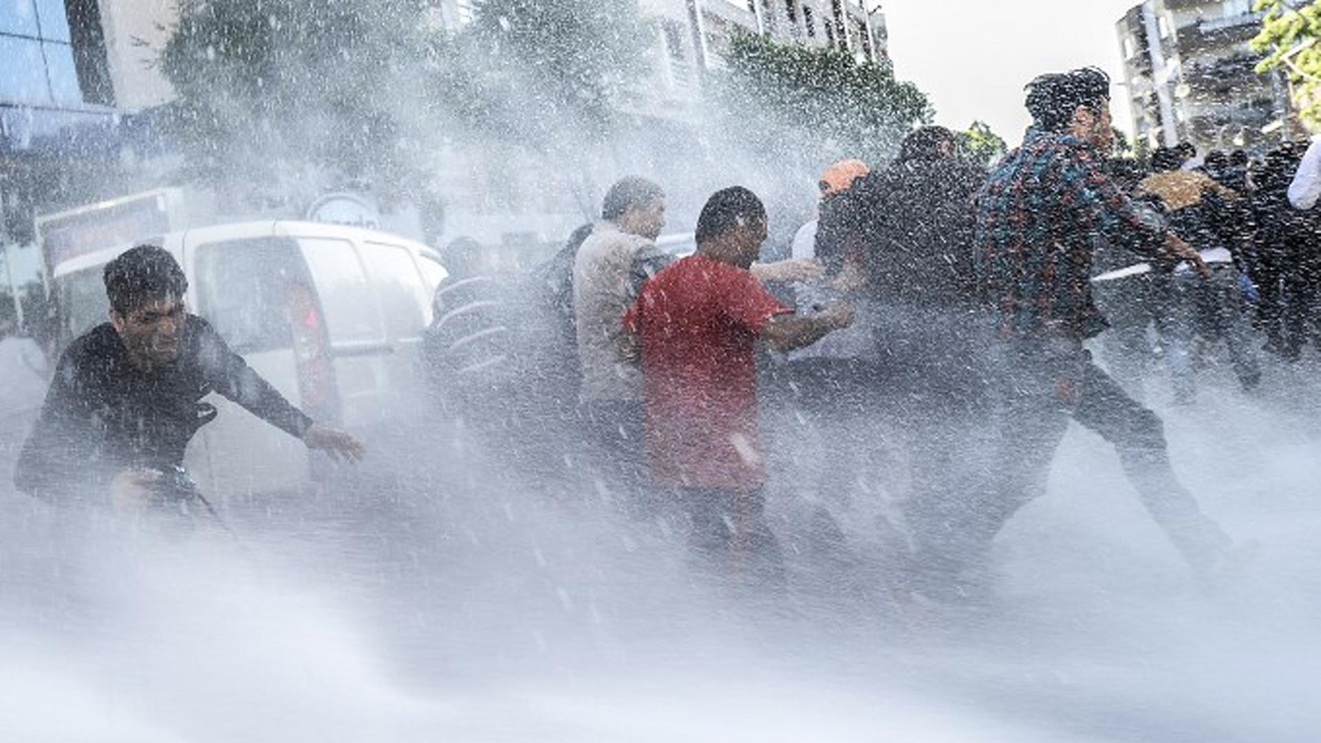 Wasserwerfer werden gegen Demonstranten eingesetzt.