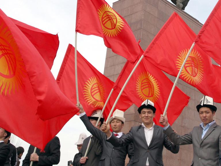 Junge Menschen in Kirgistan halten halten kirgisische Flaggen