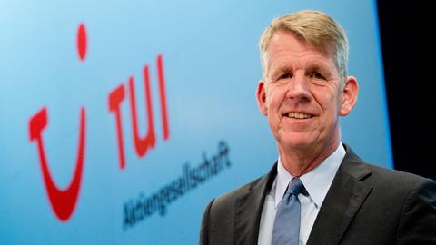 Der TUI-Vorstandsvorsitzende Friedrich Joussen steht bei der Hauptversammlung 2014 der TUI AG in Hannover (Niedersachsen) neben dem Logo des Unternehmens.