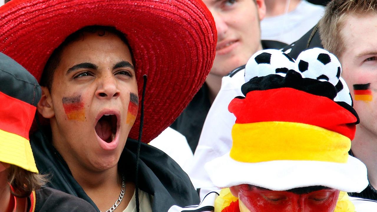 Sichtlich gelangweilt verfolgen Fußballfans am Freitag (18.06.2010) auf der Fanmeile vor dem Olympiastadion in Berlin die Niederlage der deutschen Elf bei derFußball-WM in Südafrika.