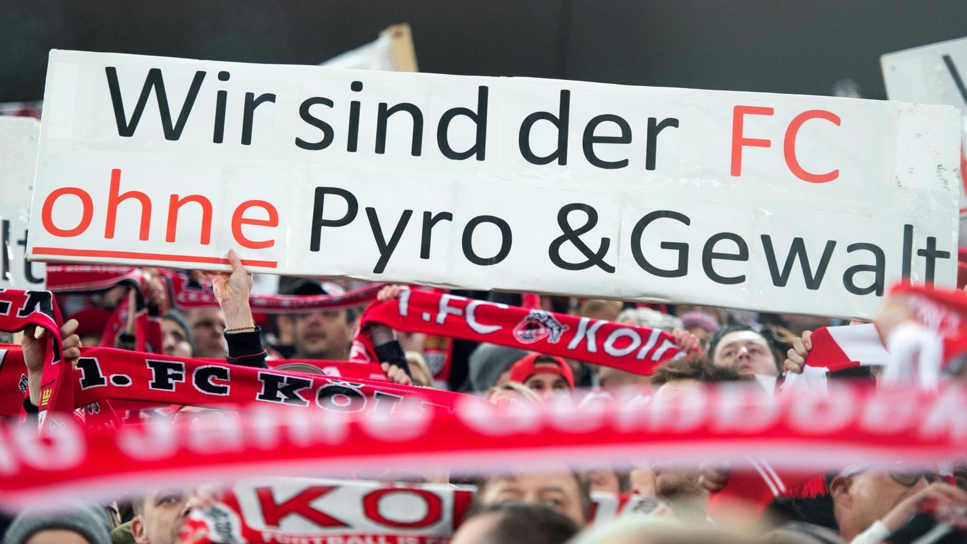 Fans im Kölner Rheinenergiestadion halten Plakate gegen Pyrotechnik hoch