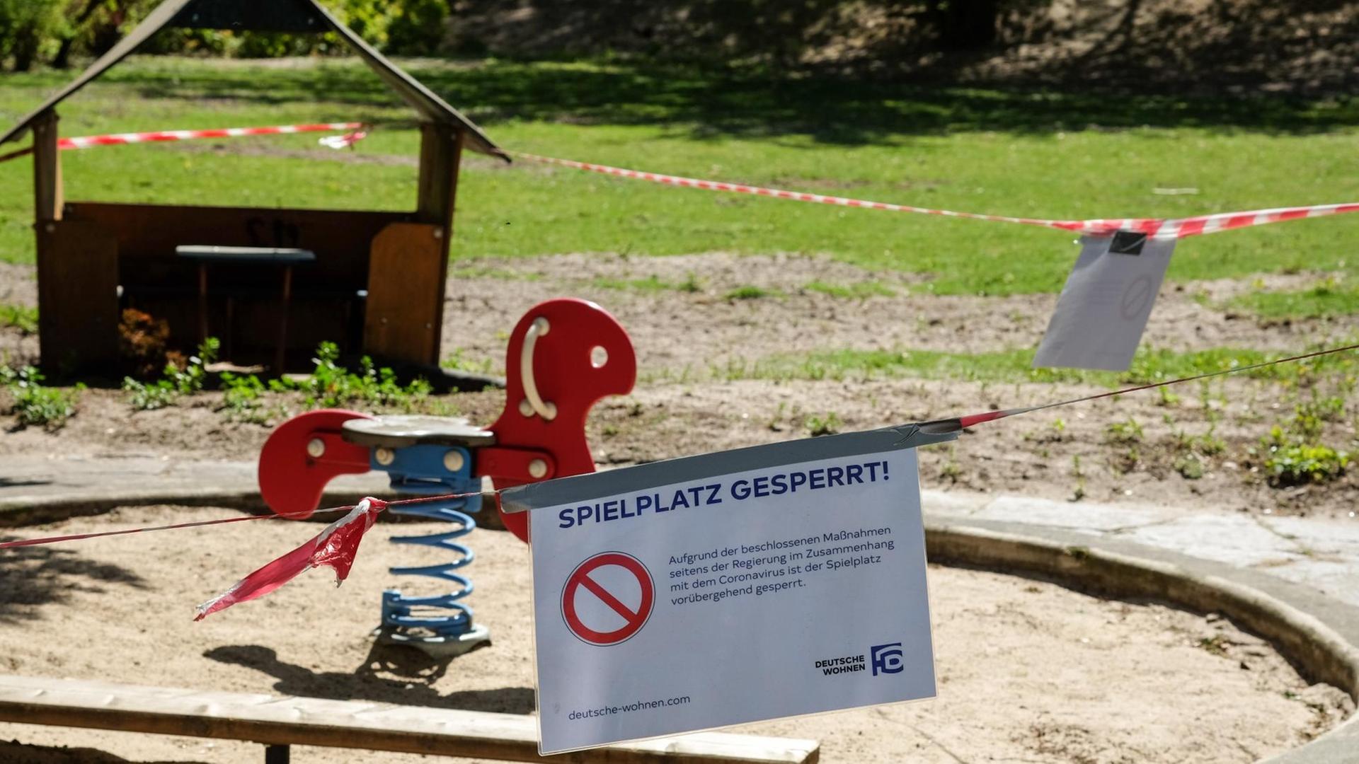Absperrbänder und ein Schild "Spielplatz gesperrt" sind an einem Spielplatz in Charlottenburg angebracht.