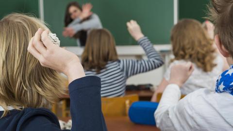 Schüler im Klassenzimmer bewerfen die Lehrerin mit Papierbällen, Mobbing gegen Lehrer