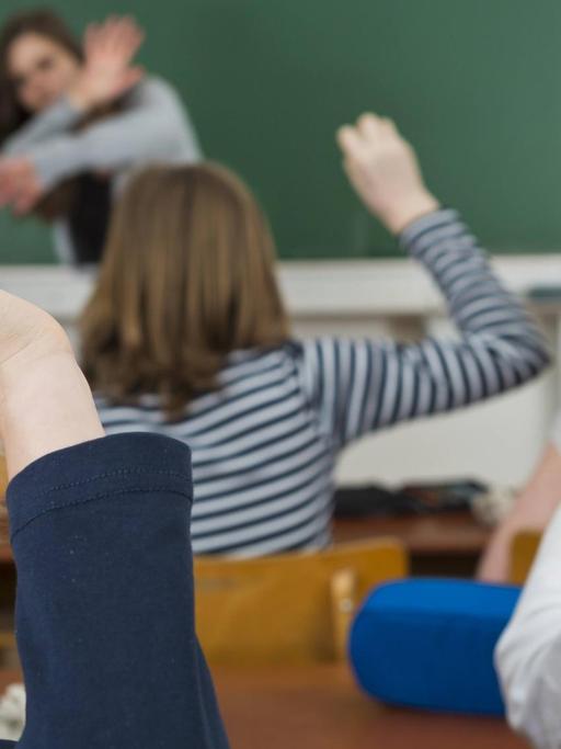 Schüler im Klassenzimmer bewerfen die Lehrerin mit Papierbällen, Mobbing gegen Lehrer