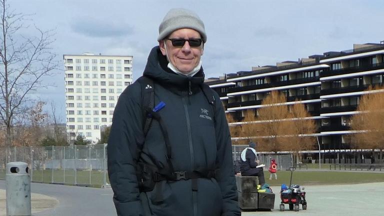 Ein Mann mit Wanderschuhen undn Outdoor-Kleidung blickt in die Kamera. Er trägt eine graue Mütze und eine Sonnenbrille. Es ist der Wanderer Hans Ruoff.