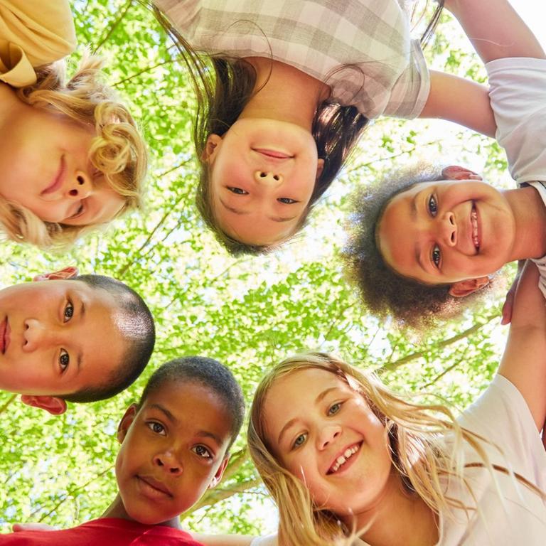 Gruppe Kinder als multikulturelles Team im Kreis
