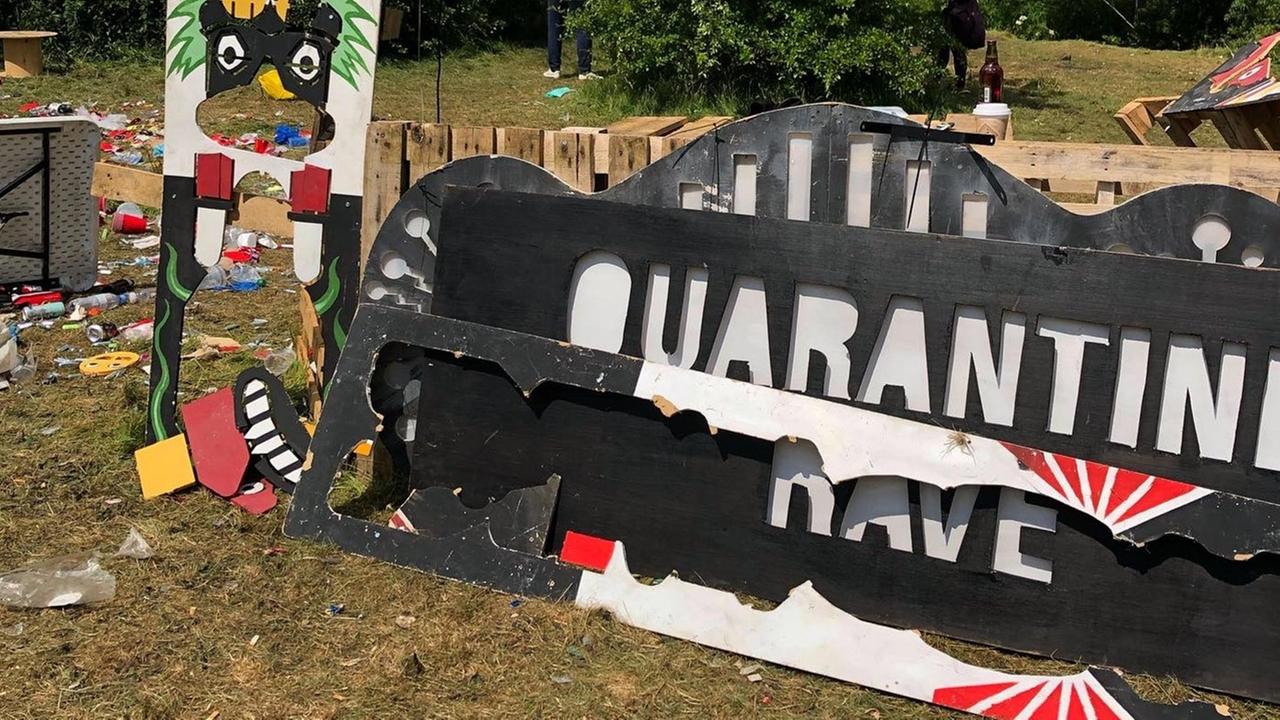 Auf einem Schild steht der Schriftzug "Quarantine Rave", daneben ist viel Müll zu sehen.