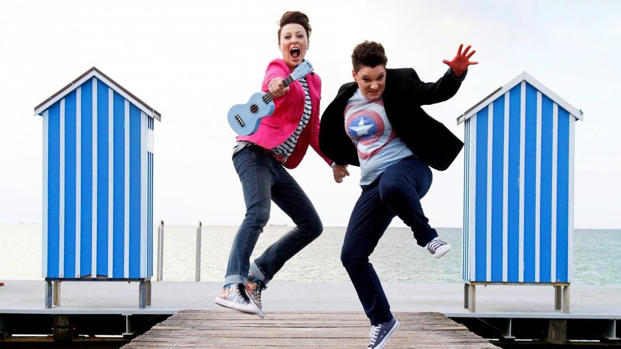 Zwei Kabarettistinnen springen in die Luft an einem Strand