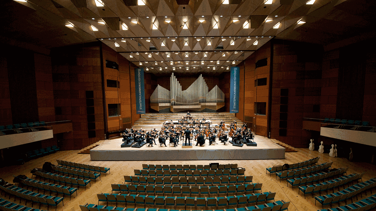 Staatsphilharmonie Nürnberg sitzend auf einer großen Bühne