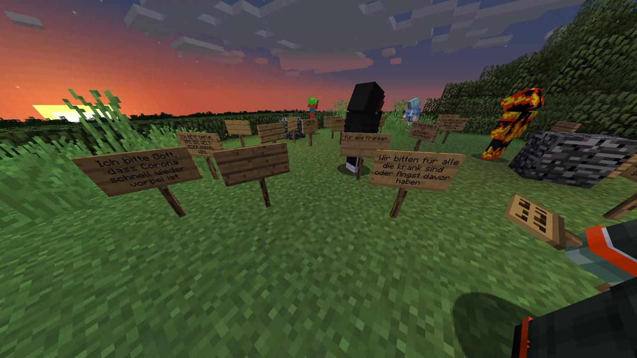 Ein Screenshot vom Minecraft-Ostergottesdienst: Auf einer Wiese stehen Schilder mit Fürbitten. "Ich bitte Gott, dass Corona schnell wieder vorbei ist", "Ich bete dafür, dass die Welt wieder normal wird", "Wir bitten für alle, die krank sind oder Angst davor haben"