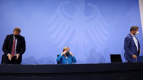 Michael Müller, Angela Merkel (CDU) und Markus Söder verlassen eine Pressekonferenz nach der Ministerpräsidentenkonferenz.