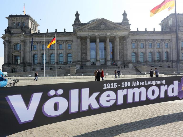 "Völkermord" ist auf dem Transparent zu lesen, das armenische Demonstranten vor dem Reichstagsgebäude in Berlin halten.