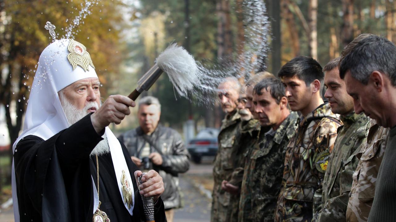 Filaret Denyssenko, Patriarch der Ukrainisch-orthodoxen Kirche Kiewer Patriarchat, segnet am 16.10.2014 Mitglieder des ukrainischen Battalions Zolotye Vorota in einem Trainingslager der Nationalgarde nahe Kiew.