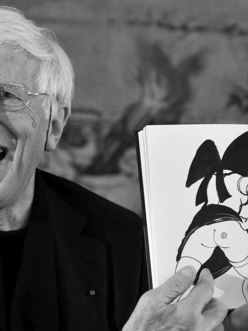 Bei einer Pressekonferenz am 15.11.2011 zeigt der elsässische Künstler Tomi Ungerer lachend eine Seite seines neuen Buches, auf der die Karikatur eine halbnackte Frau von hinten zu sehen ist.