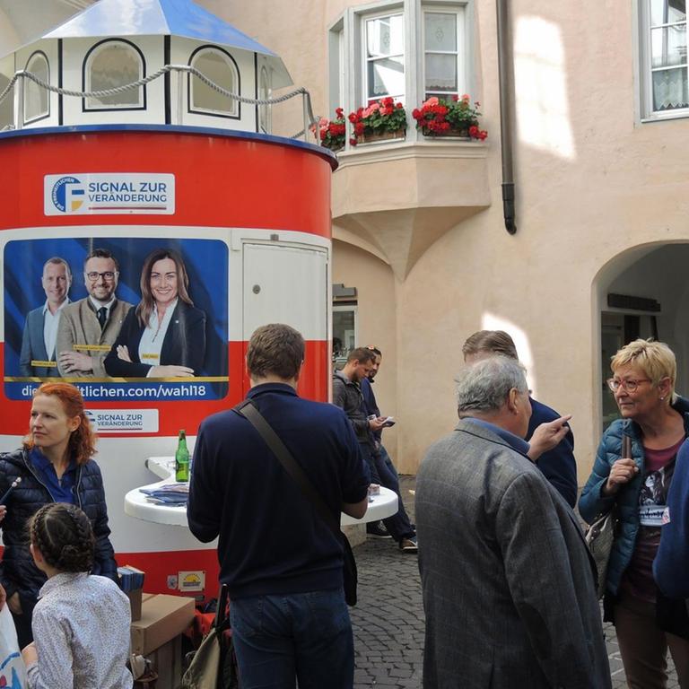 13.10.2018, Italien, Brixen: An einem Wahlkampfstand der rechtspopulistischen Partei Die Freiheitlichen werben Mitglieder der Partei um Stimmen.
