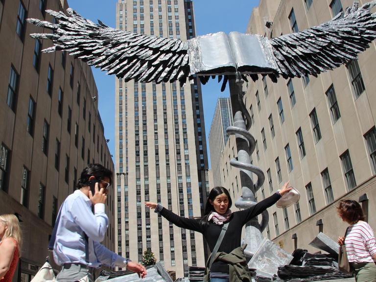 02.05.2018, USA, New York: Die Skulptur «Uraeus» von Anselm Kiefer steht vor dem Rockfeller Center. Vor dem Rockefeller Center in New York ist eine Skulptur des Künstlers Anselm Kiefer aufgestellt worden. Dutzende Menschen bestaunten und fotografierten die «Uraeus» betitelte Skulptur bereits direkt nach der offiziellen Einweihung am Mittwoch. (zu dpa «Skulptur von Anselm Kiefer vor dem Rockefeller Center aufgestellt» vom 02.05.2018) Foto: Christina Horsten/dpa | Verwendung weltweit
