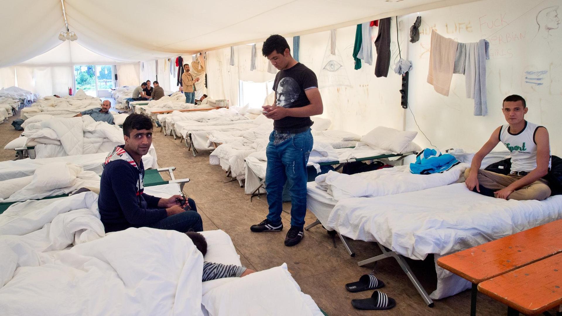 Flüchtlinge auf ihren Betten in einem Zelt der Hessischen Erstaufnahmeeinrichtung in Gießen.