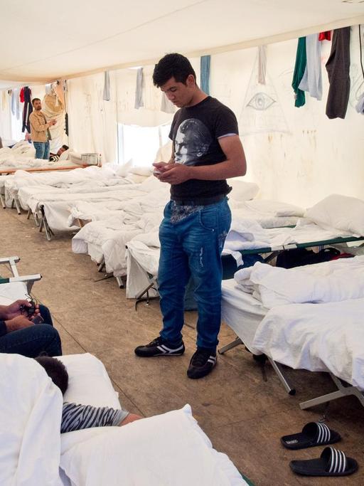 Flüchtlinge auf ihren Betten in einem Zelt der Hessischen Erstaufnahmeeinrichtung in Gießen.