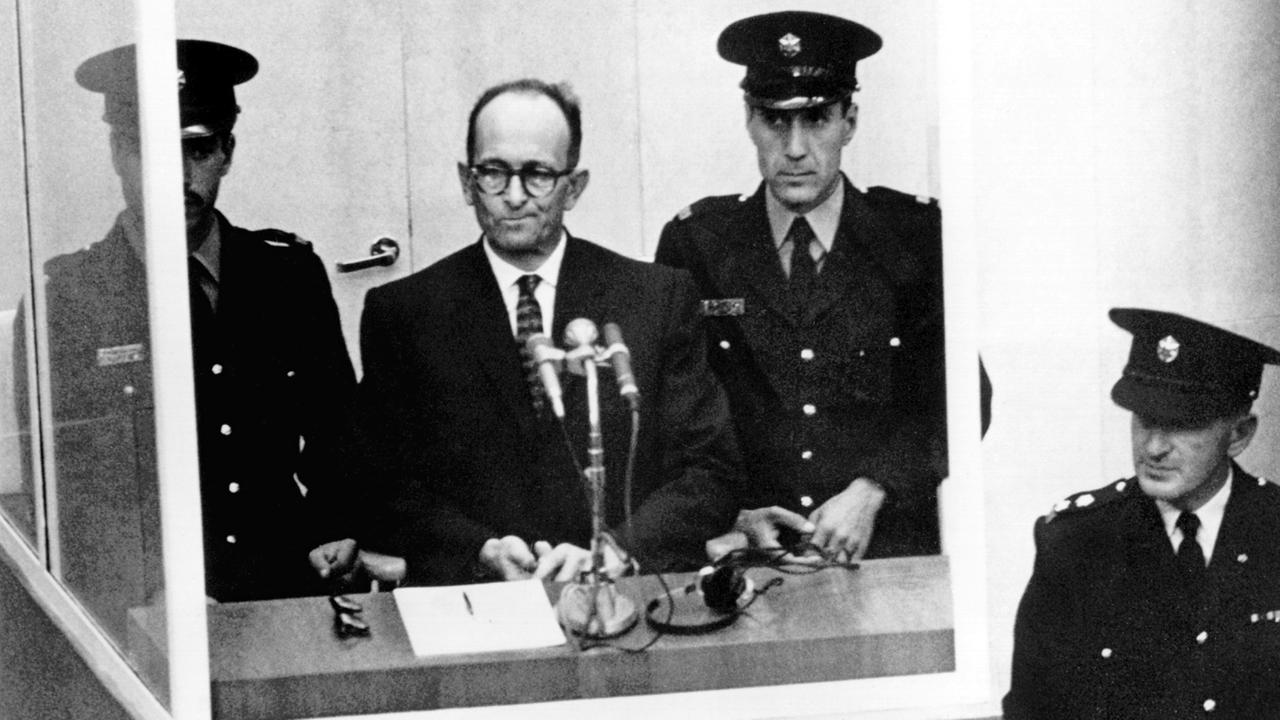 Adolf Eichmann steht am 4. November 1961 umringt von Wärtern vor Gericht in Jerusalem.