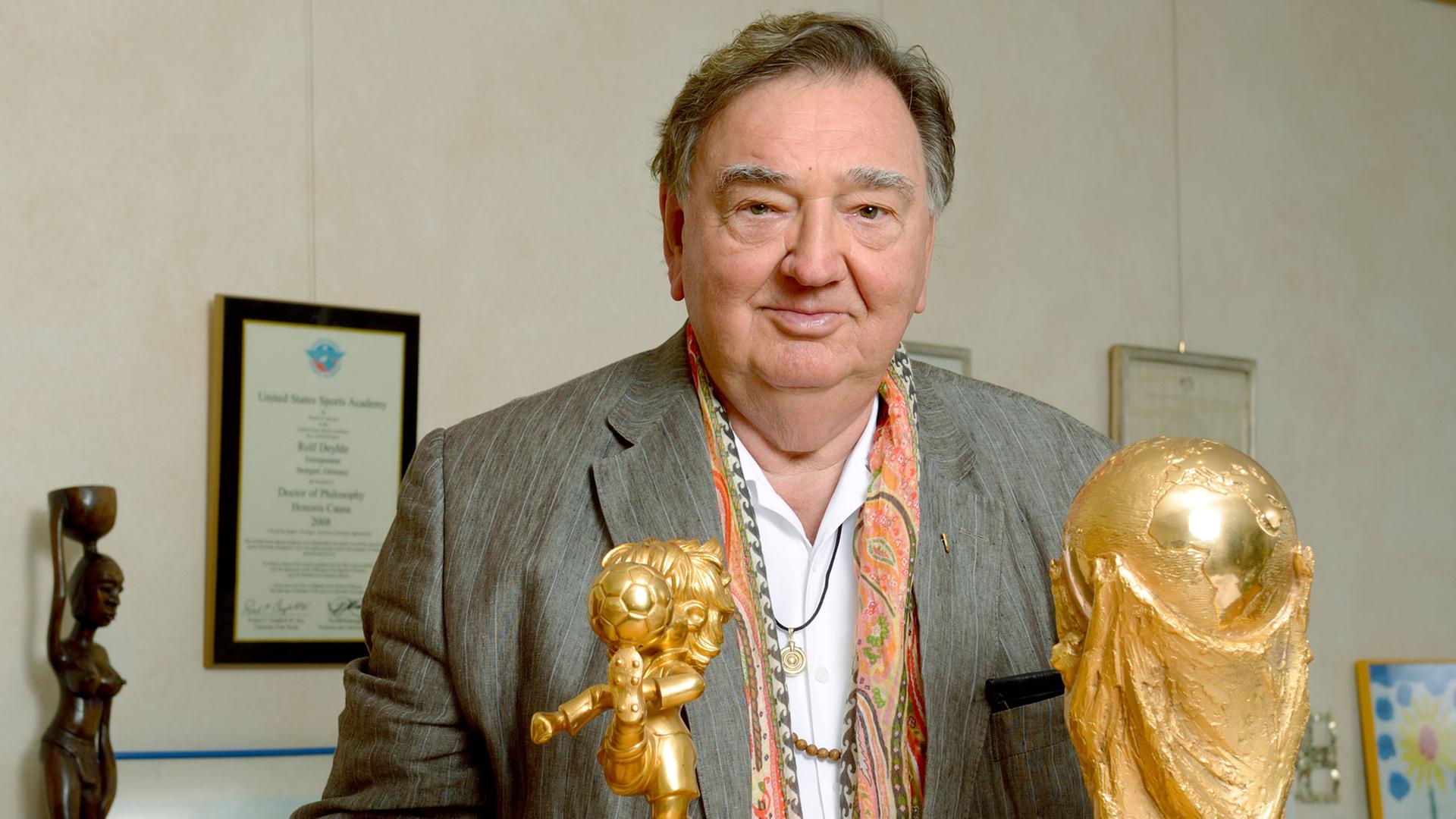 Der Unternehmer Rolf Deyhle, aufgenommen am 30.09.2013 in seinem Büro in Stuttgart (Baden-Württemberg) mit Kopien der FIFA Trophäen Fair Play und Weltpokal, die er von der FIFA als Anerkennung für seine Verdienste um den Weltfußball erhalten hat.
