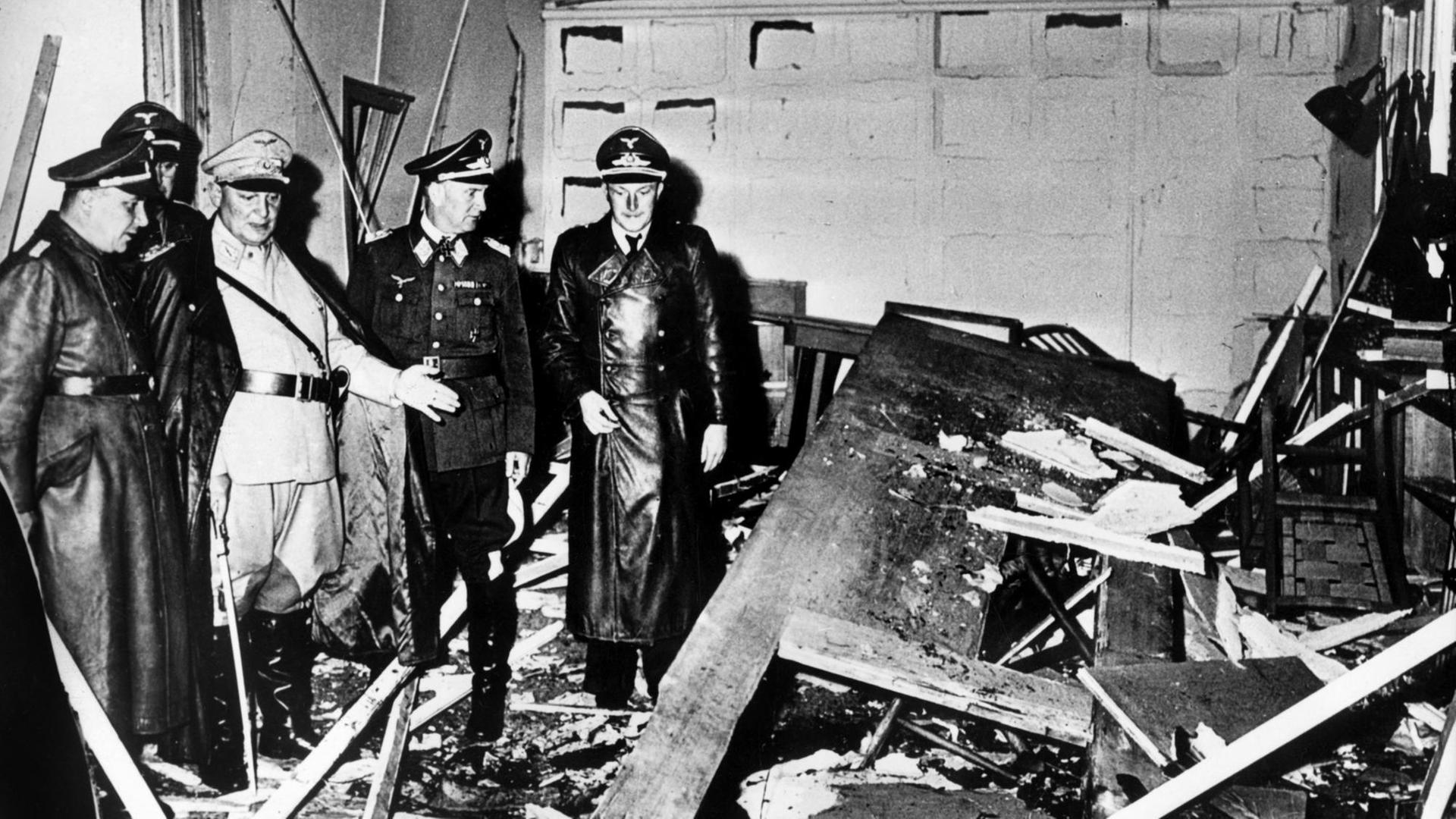 Hermann Göring (helle Uniform) und Martin Bormann (l.), begutachten die Zerstörung im Führerhauptquartier, wo Oberst Stauffenberg am 20. Juli 1944 eine Sprengladung zündete.