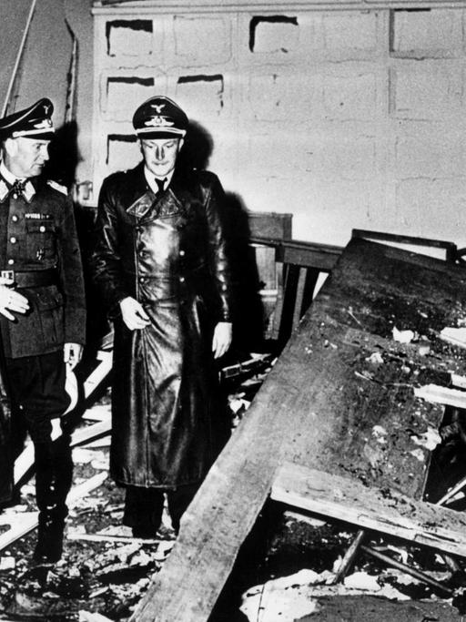 Hermann Göring (helle Uniform) und Martin Bormann (l.), begutachten die Zerstörung im Führerhauptquartier, wo Oberst Stauffenberg am 20. Juli 1944 eine Sprengladung zündete.