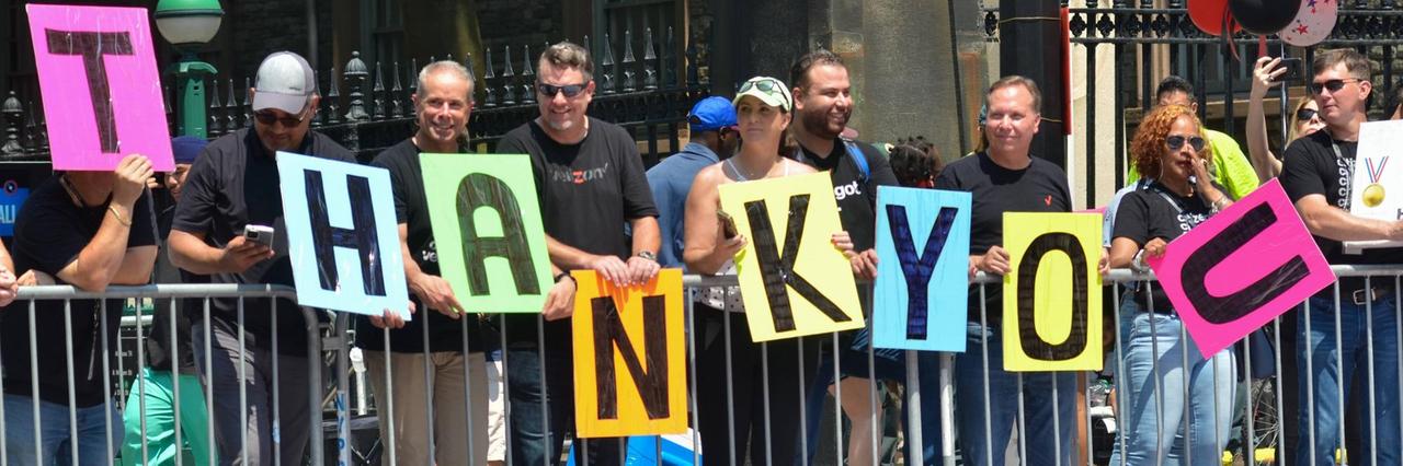 Das Foto zeigt die Parade zum Dank an die Helden der Pandemie in New York. Hier halten Menschen "Thank-you-Schilder" hoch.