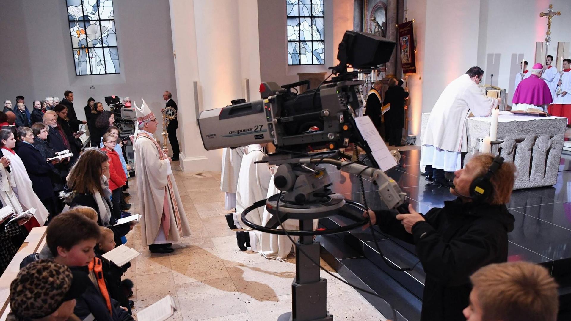 Ein Kameramann filmt während eines Gottesdienstes die Zeremonie