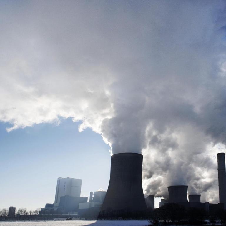 Rauchwolken über dem Braunkohlekraftwerk Niederaußem, betrieben durch RWE Power in Bergheim. (Mit Denkfabrikstempel)