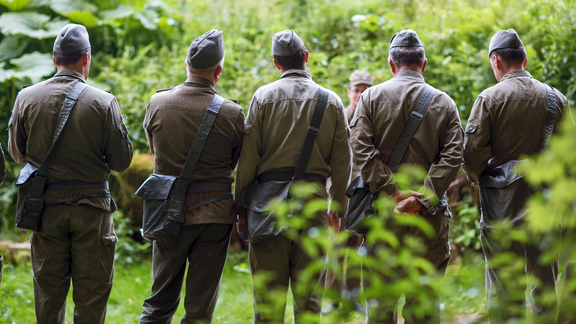 Besucher in NVA-Uniform nehmen im Bunkermuseum im Thüringer Wald an einer Armeeübung teil.