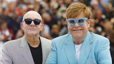 Bernie Taupin und Elton John posoeren nebeneinander auf den Filmfestspielen in Cannes