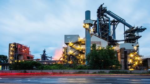 Der abendliche Autoverkehr fährt an Dillinger Hütte vorbei. Die Dillinger Hütte, Muttergesellschaft AG der Dillinger Hüttenwerke, wurde 1685 gegründet und ist das größte Grobblechwerk Europas. Dillingen ist der einzige Produktionsstandort von Roheisen im Saarland.