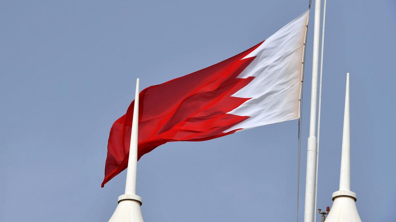 Die Flagge von Bahrain ist rot-weiß mit Zacken zwischen den Farbfelder. Sie weht im Wind.