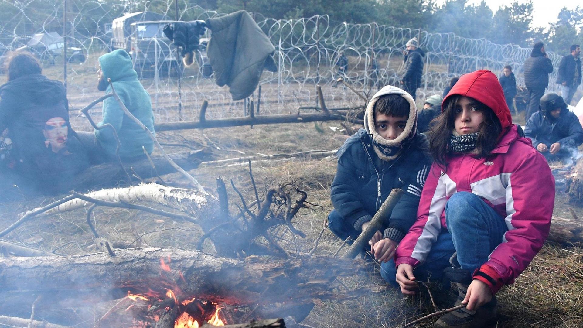 Kinder an einem Feuer an der Grenze zwischen Polen und Belarus.
