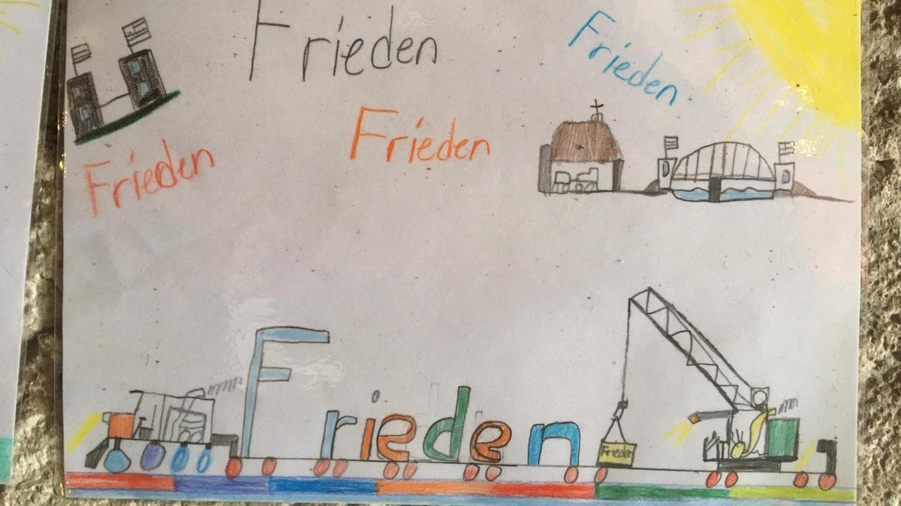 Ein Kinderbild mit der Brücke von Remagen und dem Wort "Frieden", mehrfach in bunter Schrift geschrieben