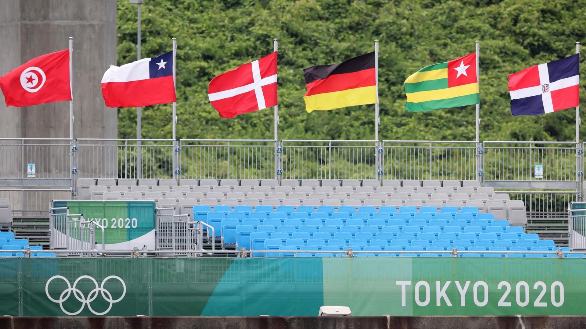 Fahnen verschiedener Nationen wehen über der leeren Tribüne bei den Olympischen Sommerspielen in Tokio.