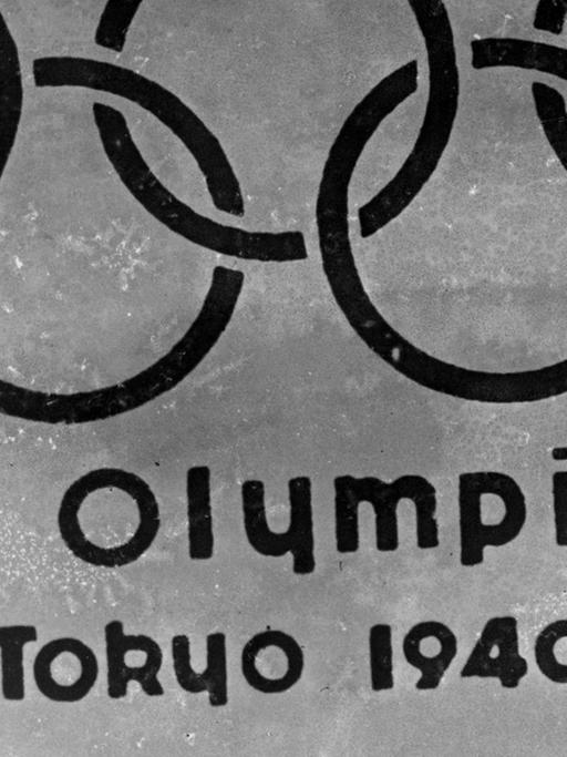 Ein altes Embelem mit den Olympischen Ringen vor dem Berg Fuji und der Inschrift XII Olympiad Tokyo 1940