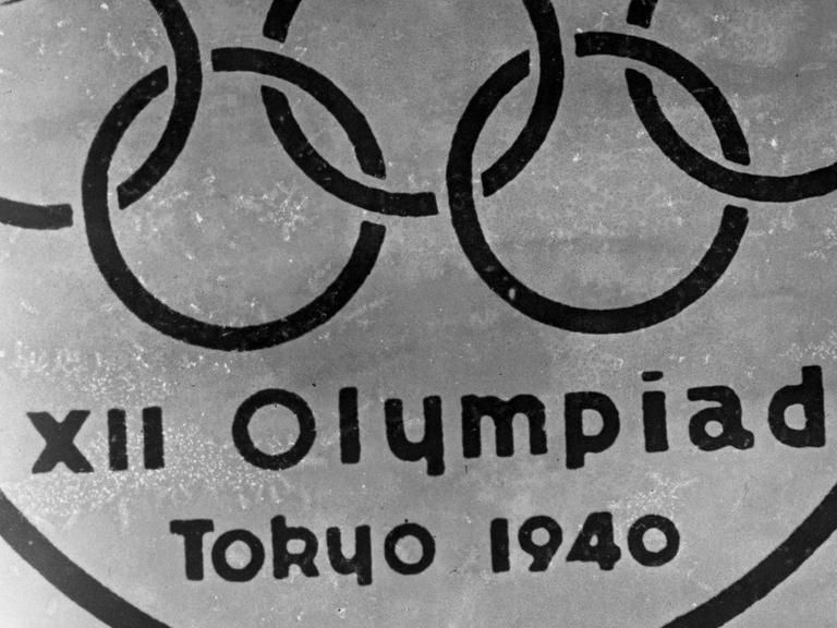 Ein altes Embelem mit den Olympischen Ringen vor dem Berg Fuji und der Inschrift XII Olympiad Tokyo 1940